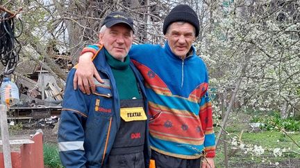 Olexander et son ami Viktor, à Borodianka. "Olexander, à gauche, retrouve Viktor, le parrain de ses enfants, dans le jardin de ce dernier. Sa maison, elle, a été quasiment soufflée et l’appartement d’Olexander, dans la rue d’en face, détruit." (FARIDA NOUAR / FRANCEINFO / RADIO FRANCE)