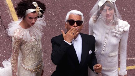 Le couturier allemand Karl Lagerfeld embrasse son public à l'issue du défilé Chanel automne / hiver 2001-2002 à Paris, le 9 juillet 2001. (PHILIPPE WOJAZER / REUTERS)