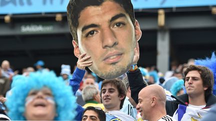 Des supporters uruguayens soul&egrave;vent un portrait g&eacute;ant de leur attaquant vedette Luis Suarez, le 19 juin 2014 &agrave; Sao Paulo (Br&eacute;sil). (LUIS ACOSTA / AFP)