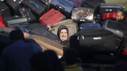 Une Palestinienne qui tente de passer en Egypte cherche sa valise lors d'une pause &agrave; Rafah (Palestine), le 30 septembre 2013. (IBRAHEEM ABU MUSTAFA / REUTERS)