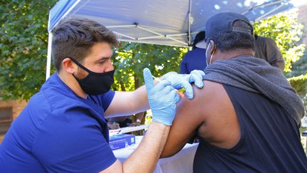 Un soignant administre une dose du vaccin contre le Covid-19 de Pfizer, dans un centre de vaccination à New York, aux Etats-Unis, le 21 octobre 2021. (MICHAEL M. SANTIAGO / GETTY IMAGES NORTH AMERICA / AFP)