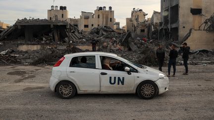 Une voiture de l'ONU passe devant les décombres d'un bâtiment après des frappes israéliennes à Rafah, dans le sud de la bande de Gaza, le 22 novembre 2023. (SAID KHATIB / AFP)