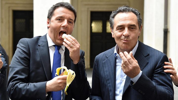 Le 28 avril 2014, &agrave; Rome (Italie),&nbsp;le pr&eacute;sident du Conseil italien Matteo Renzi (&agrave; gauche) imite Dani Alves qui a r&eacute;pondu &agrave; un jet de banane en mangeant le fruit. (MAXPPP)