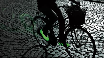 Pour se protéger, voir ne suffit pas. Il faut aussi être vu ! Sur un vélo, la nuit, la première des sécurités est la sécurité passive en portant des vêtements ou accessoires luminescents. Avec la mouillère®, photoluminescente, ludique et fonctionnelle, la sécurité devient fun. Cette sur-chaussure en caoutchouc synthétique emmagasine la lumière électrique ou naturelle et la restitue avec une autonomie de 14h. Elle s’enfile sur ses chaussures pour les protéger et prolonger leur durée de vie, se retire en quelques secondes et se plie. Disponible du 37 au 46. Prix : 65 euros. 
 (Mymouillere)