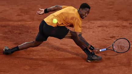 Gaël Monfils en glissade contrôlée sur le court Philippe-Chatrier, lors de son 1er tour de Roland-Garros contre l'Argentin Sebastian Baez, le 30 mai 2023. (ANNE-CHRISTINE POUJOULAT / AFP)