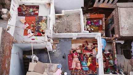 "Je suis arrivée à ma pension à Varanasi à 5:30 du matin, j'ai instinctivement grimpé les 7 étages jusqu'à la terrasse (qui est la plus haute des environs) pour voir le soleil se lever sur le Gange. Alors que le soleil se levait, j'ai regardé par dessus le balcon et ma machoire est tombée d'incrédulité. Au dessous se trouvaient des familles - mères, pères, enfants, frères, soeurs et chiens, dormant tous sur le toit de leur maison. Nous étions au milieu de l'été à Varanasi et dormir sans air conditionné était difficile."
 (Yasmin Mund / National Geographic)