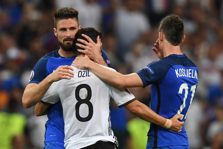 Olivier Giroud et Laurent Koscielny réconfortent leur partenaire d'Arsenal, l'Allemand Mesut Özil, après la demi-finale de l'Euro, jeudi 7 juillet 2016 au Stade de France. (PATRIK STOLLARZ / AFP)