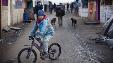 Jahangir, un orphelin afghan âgé de 10 ans,&nbsp;fait du vélo dans la jungle de Calais, le 23 février 2016. Ses deux parents sont morts durant&nbsp;la guerre. (MAXPPP)