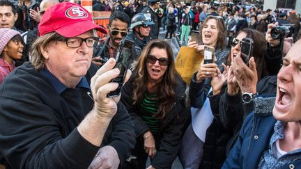 Le réalisateur Michael Moore, qui avait prédit la victoire de Trump, filme sur son portable la manifestation anti-Trump, le samedi 12 novembre, à New-York.&nbsp; (CORDON PRESS/SIPA)