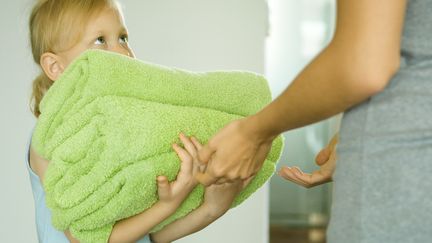 Une fille aide sa mère à ranger du linge. (ERIC AUDRAS / ALTOPRESS / MAXPPP)