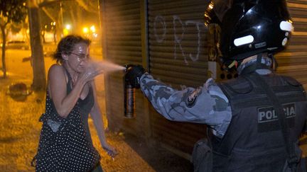 Un policier asperge une manifestante avec du spray au poivre &agrave; Rio de Janeiro (Br&eacute;sil), le 17 juin 2013. (VICTOR R. CAIVANO / AP / SIPA)