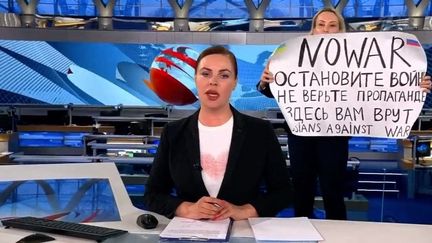 Une femme interrompt le journal télévisé avec une pancarte&nbsp;sur laquelle on peut lire&nbsp;"Non à la guerre. Ne croyez pas à la propagande. On vous ment ici", le 14 mars 2021 sur le plateau de Pervy Kanal, à Moscou (Russie).&nbsp; (EYEPRESS NEWS / AFP)