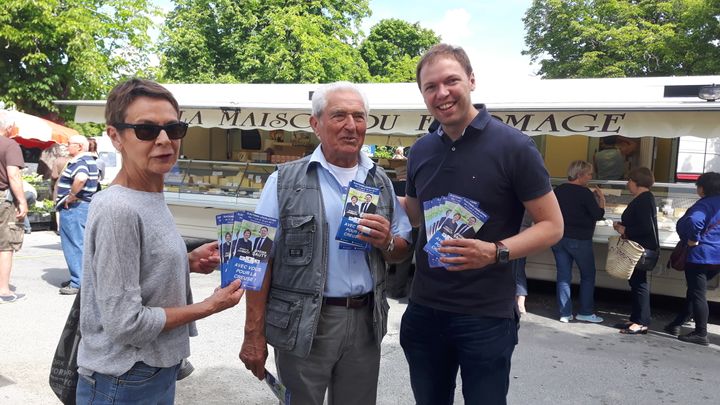 Le candidat Les Républicains Jeremy&nbsp;Sauty (à gauche) et des militants sur le marché de&nbsp;Dun-le-Palestel. (ISABELLE RAYMOND / RADIO FRANCE)