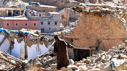 Un homme marche entre les débris dans le village d'Ardouz (Maroc), le 14 septembre 2023. (FETHI BELAID / AFP)