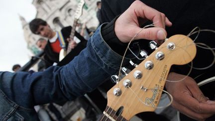 Un guitariste monte les cordes de son instrument
 (PIERRE ANDRIEU/AFP)