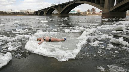 Un membre du club des nageurs "Cryophil" se laisse flotter sur un bloc de glace sur l'Ienisse&iuml; &agrave; Krasnoyarsk (Russie), le 18 avril 2012. (ILYA NAYMUSHIN / REUTERS)