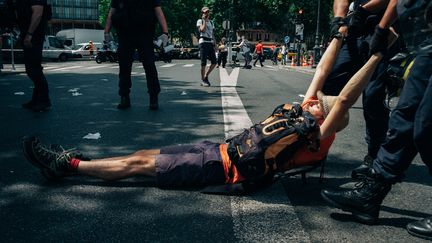 Des forces de l'ordre tirent un activiste écologique lors d'une manifestation sur le pont de Sully à Paris, le&nbsp;28 juin 2019. (MATHIAS ZWICK / HANS LUCAS)