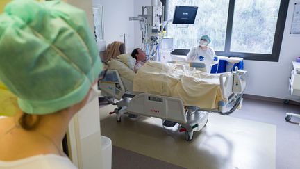 Des infirmières au chevet d'un patient souffrant du Covid-19 à l'hôpital Purpan de Toulouse le 27 novembre 2020. (FREDERIC SCHEIBER / HANS LUCAS / AFP)