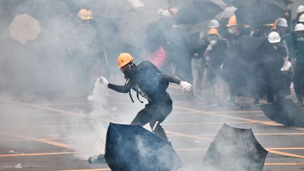 Un manifestant renvoie une grenade lacrymogène, le 27 juillet 2019, à&nbsp;Hong Kong. (ANTHONY WALLACE / AFP)