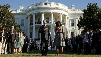 Barack et &nbsp;Michelle Obama observent une minute de silence sur la pelouse de la Maison Blanche, &agrave; Washington (Etats-Unis), le 11 septembre 2015. (KEVIN LAMARQUE / REUTERS)