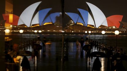 De l'autre côté du globe, l'Opéra de Sydney (Australie) aux couleurs du drapeau français, dont le reflet est projeté sur une façade. (JASON REED / REUTERS)