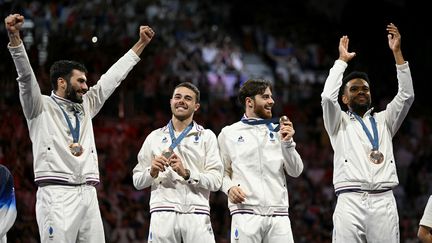 L'équipe de France masculine de sabre, après avoir remporté la médaille de bronze aux Jeux de Paris, le 31 juillet 2024. (FABRICE COFFRINI / AFP)