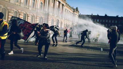 Des manifestants dispersés par des canons à eau lors d'une manifestation de "gilets jaunes", le 9 février 2019 à Toulouse. (VALENTIN BELLEVILLE / HANS LUCAS / AFP)