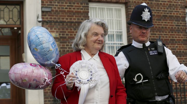 Une femme se fait raccompagner par un policier apr&egrave;s avoir pris une photo devant l'h&ocirc;pital St Mary, o&ugrave; doit accoucher Kate Middleton,&nbsp;&agrave; Londres (Royaume-Uni), le 15 juillet 2013. (OLIVIA HARRIS / REUTERS)