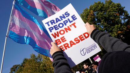 Des manifestants protestent devant la Maison Blanche, à Washington, avec une pancarte indiquant "les personnes trans ne seront pas effacées", le 22 octobre 2018. (KEVIN LAMARQUE / REUTERS)