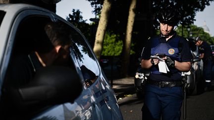 Un agent de la surveillance de Paris verbalise un conducteur, le 1er juillet à Paris. (PHILIPPE LOPEZ / AFP)