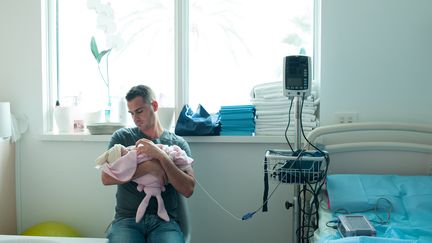 Un père et son bébé nouveau-né dans un maternité d'une clinique de Nice (Alpes-Maritimes), le 25 avril 2014. (ALBANE NOOR / BSIP / AFP)