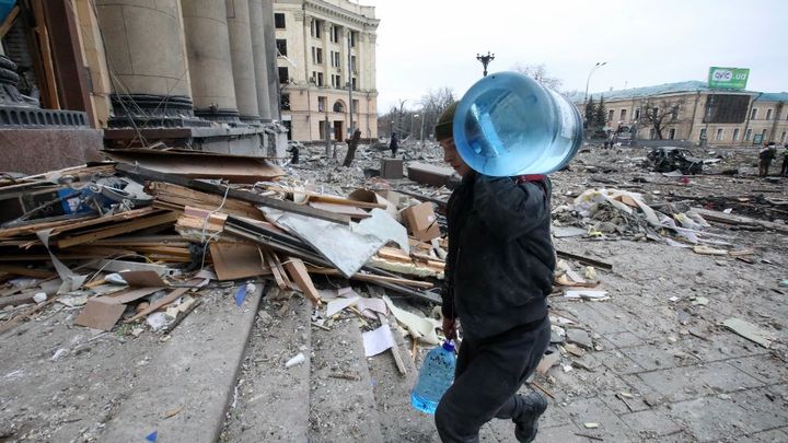 Mardi 1er mars 2022, à Kharkiv, en Ukraine, un homme transporte&nbsp;une bonbonne&nbsp;d'eau, après qu'un missile russe a frappé à l'extérieur du bâtiment du palais de l'administration régionale, vers 8h du matin.&nbsp; (VYACHESLAV MADIYEVSKYY / NURPHOTO VIA AFP)