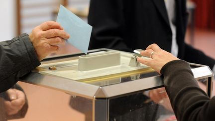 Un électeur glisse son bulletin dans l'urne, lors des élections régionales, le 13 décembre 2015 à Quintin (Côtes-d'Armor). (FRED TANNEAU / AFP)