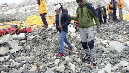 Un homme aide une femme bless&eacute;e au camp de base du mont Everest, dimanche 26 avril 2015.&nbsp; (AZIM AFIF / AP / SIPA)