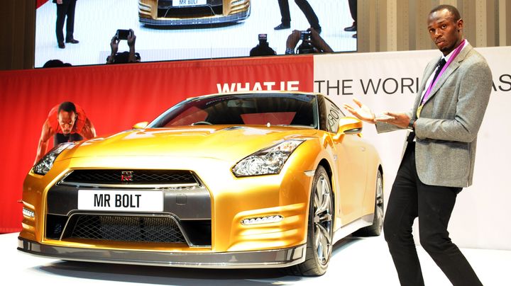 Le champion olympique Usain Bolt pose pr&egrave;s d'un Nissan GT-R dor&eacute;, &agrave; Yokohama (Japon), le 11 octobre 2012. (RIE ISHII / AFP)