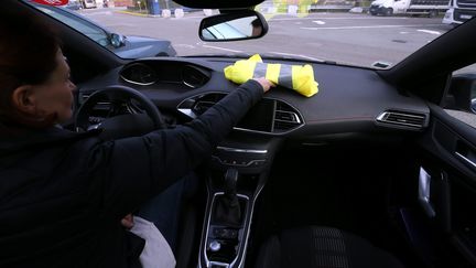 Une automobiliste pose un gilet jaune sur son tableau de bord, à Pont-de-Roide (Doubs), le 4 novembre 2018. (MAXPPP)