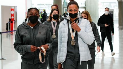 Grâce Zaadi et Allison Pineau lors de leur retour en France, à l'aéroport de Roissy, le lundi 20 décembre 2021. (GEOFFROY VAN DER HASSELT / AFP)