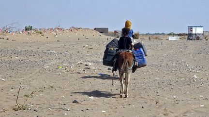 Des filles chevauchent un âne chargé de jerricans dans un camp de fortune, près de la zone de conflit dans la province occidentale de Hodeida, au Yémen, le 4 décembre 2021.&nbsp; (KHALED ZIAD / AFP)