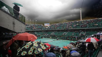 Le match entre Roger Federer et Robin S&ouml;derling est interrompu par la pluie, le 1er juin 2010, &agrave; Roland-Garros. (POPPERFOTO / GETTY IMAGES)