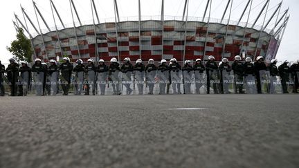 Des policiers polonais montent la garde autour du stade de Varsovie (Pologne) avant le match de l'Euro opposant la Pologne &agrave; la Russie, le 12 juin 2012. (KAI PFAFFENBACH / REUTERS)