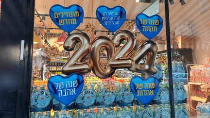 Une épicerie de Tel-Aviv a collé sur sa vitrine des messages pour 2024 : "Qu'on ait une meilleure année civile, une année d’espoir. Une année d’amour. Une année d’unité." (WILLY MOREAU / FRANCEINFO / RADIO FRANCE)