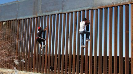 A Ciudad Juarez,  deux jeunes Mexicains s'amusent à escalader le mur de séparation entre leur pays et les Etats-Unis, le 26 janvier 2017. (HERIKA MARTINEZ/AFP)