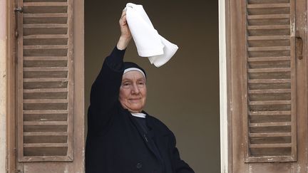 Une nonne salue le pape Beno&icirc;t XVI lors de sa derni&egrave;re apparition &agrave; la fen&ecirc;tre de Castel Gandolfo (Italie), le 28 f&eacute;vrier 2013. (TONY GENTILE / REUTERS)