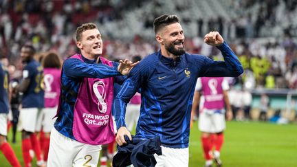 Benjamin Pavard et Olivier Giroud fêtent la victoire de la France contre la Pologne en huitièmes de finale de la Coupe du monde 2022, le 4 décembre. (AYMAN AREF / AFP)