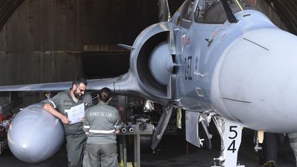 Des militaires de l'armée de l'air française au pied d'un avion de combat Mirage 2000-5 sur la base de Luxeuil-Saint-Sauveur (Haute-Saône), le 24 juin 2019. (SEBASTIEN BOZON / AFP)