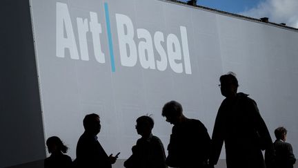 Les silhouettes de visiteurs de Art Basel, en Suisse, première foire d'art contemporain, en 2019.&nbsp; (FABRICE COFFRINI / AFP)