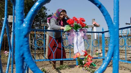 Moment de recueillement au cimetière. 

Comme les autres visiteurs, la vieille dame profitera de cette visite annuelle pour nettoyer et refleurir les tombes. (REUTERS/Vasily Fedosenko)