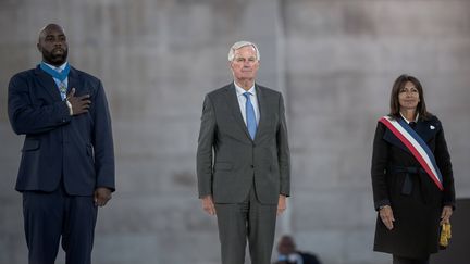 Michel Barnier, entouré de Teddy Riner et d'Anne Hidalgo, participe à la Parade des Champions célébrant les médaillés des Jeux, le 14 septembre 2024, à Paris. (NICOLAS MESSYASZ/SIPA)