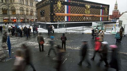 Des touristes passent pr&egrave;s de la malle g&eacute;ante Louis Vuitton install&eacute;e sur la place Rouge &agrave; Moscou (Russie), le 27 novembre 2013. (PAVEL GOLOVKIN / AP / SIPA)