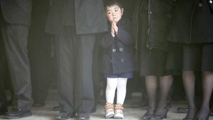 Un petit gar&ccedil;on fait une pri&egrave;re lors d'un rassemblement devant une &eacute;cole primaire d'Ishinomaki (Japon)&nbsp;en m&eacute;moire des victimes du tsunami, le 10 mars 2013. (HIROTO SEKIGUCHI / AP / SIPA)